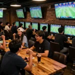 Engaged fans betting on sports at a lively bar featuring 7meter Judi Bola.